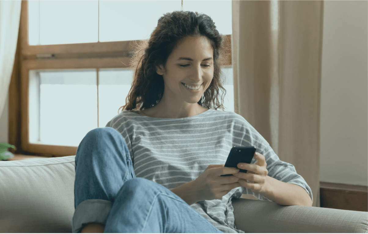 A woman smiling and looking at her phone